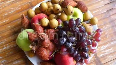 美味可口的热带水果放在木桌上的碗里。 最高的视野。 慢动作。 1920x1080